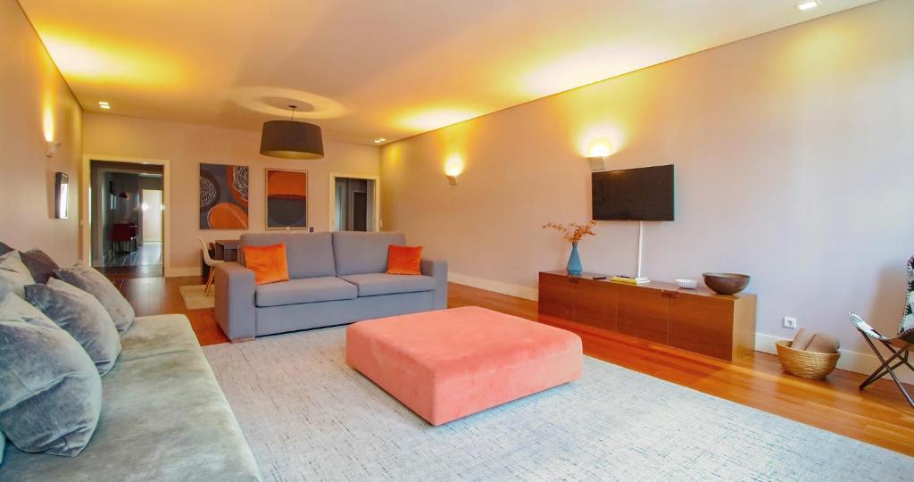 a living room with a couch and a tv at ALIADOS by YoursPorto in Porto
