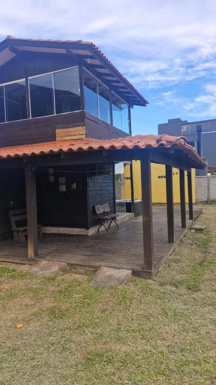 a building with a roof with a bench on a deck at Casa Buddha in Imbituba