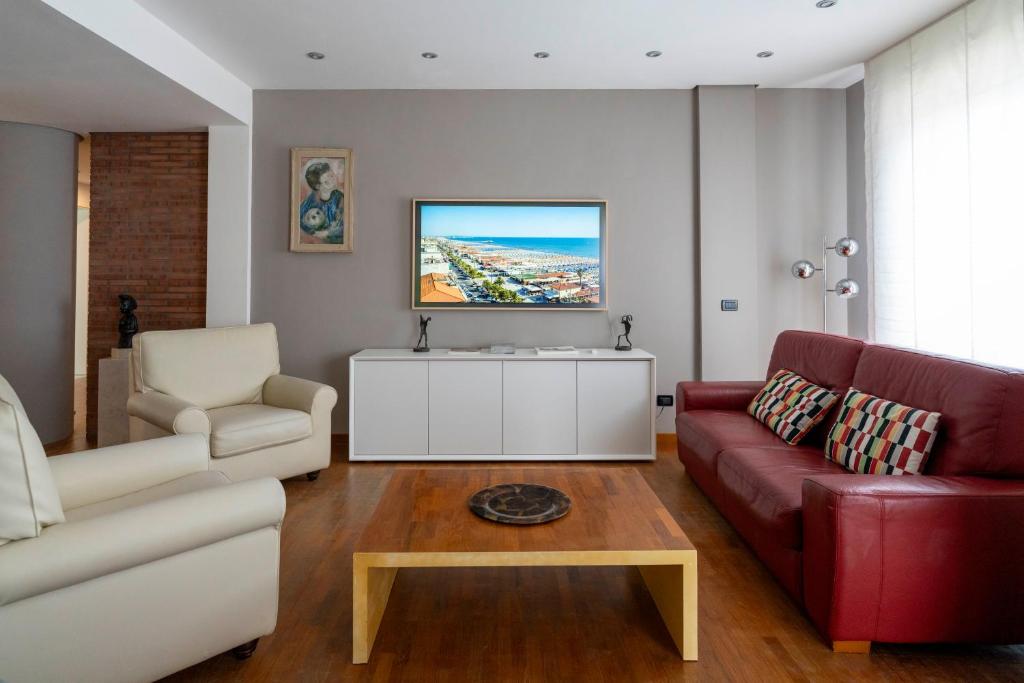 a living room with a couch and a tv at Charming beach front apartment in Viareggio