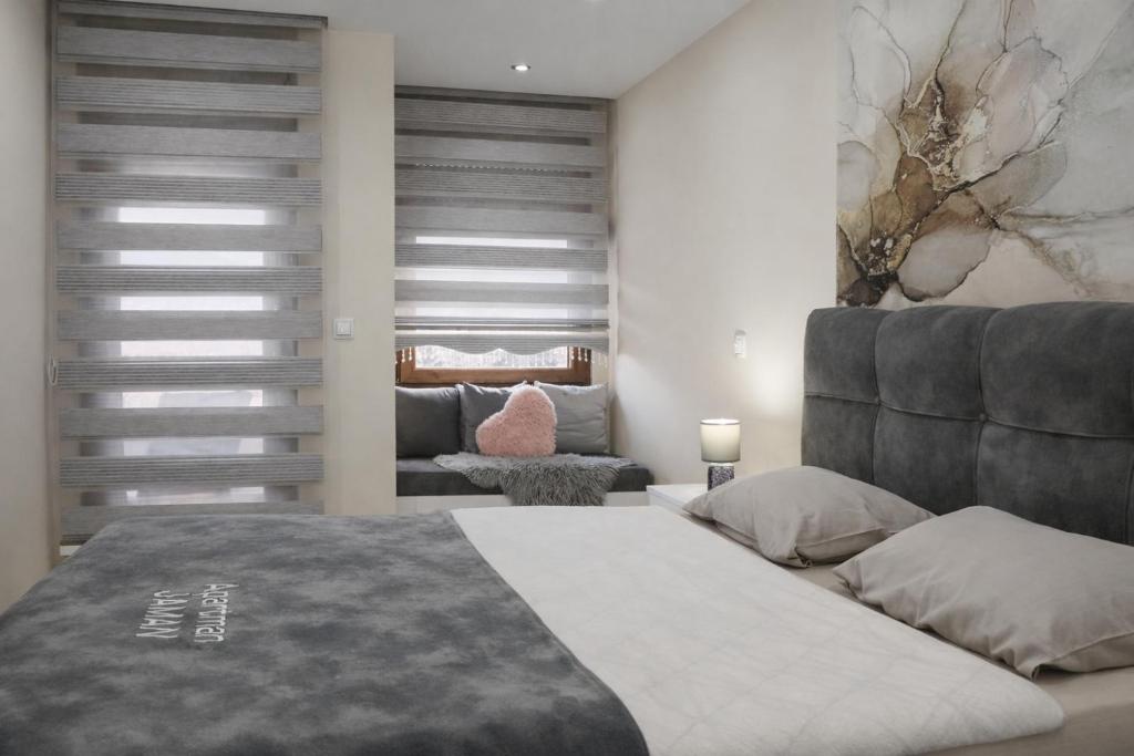 a bedroom with a large bed and a couch at Apartman Jaman - Novi Pazar in Novi Pazar