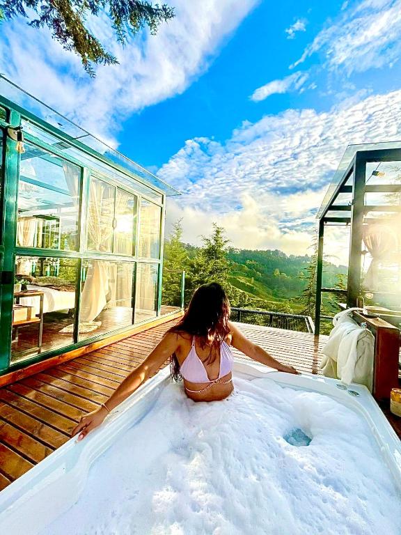 a woman sitting in a bath tub on a deck at Kamarí Glamping in San Francisco