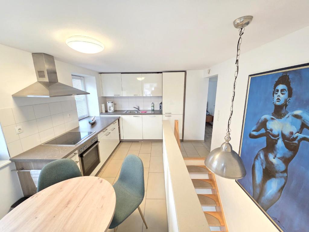 a kitchen with a large painting of a woman on the wall at Bodensee Ferienwohnung Claudia 4 in Friedrichshafen