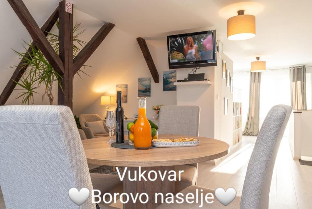 a living room with a wooden table and chairs at Chic Palace - Boutique studio apartment in Vukovar