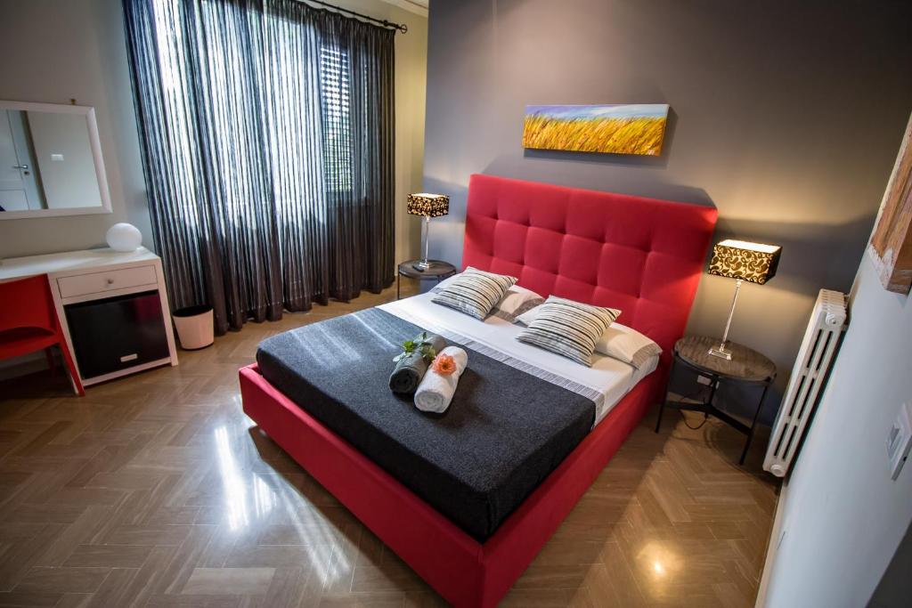 a bedroom with a red bed with a red headboard at B&B Le Muse in Mondello