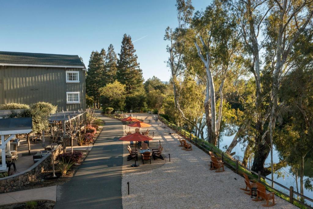 a street with tables and umbrellas next to a river at River Terrace Inn in Napa