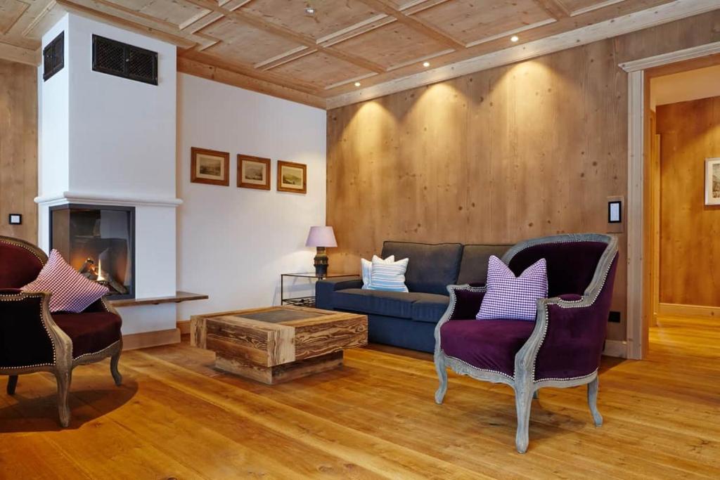 a living room with a blue couch and chairs at Suite Buche - Chalet Bergerhöh in Bad Wiessee