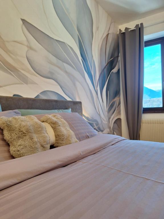 a bed with a teddy bear laying on it at Affittacamere La Polse in Osoppo