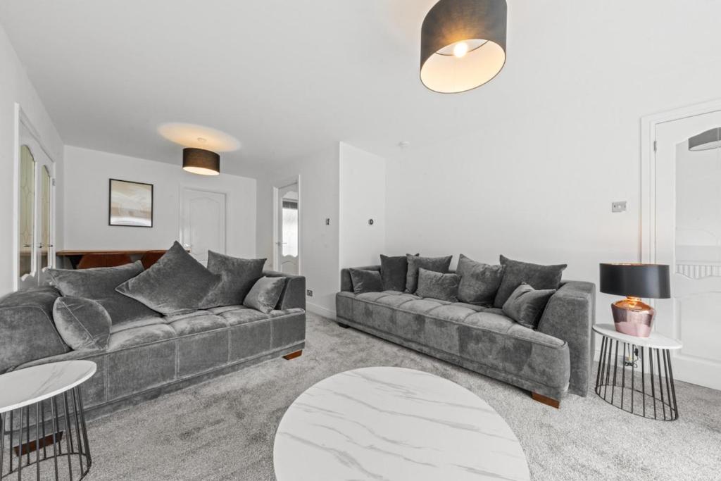 a living room with a couch and a table at Large 5 Bedroom House Perfect For Group Stays - Free Parking - Near Glasgow - Perfect For Contractors in High Blantyre