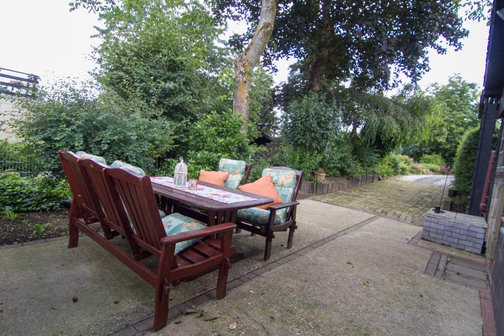 een houten tafel met drie stoelen eromheen bij Ferienhaus Wildblick in Schleiden