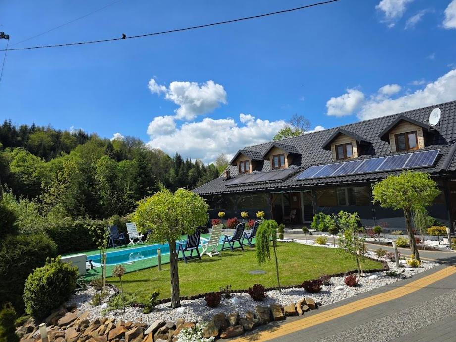 a building with a swimming pool in front of it at Jaśkowa Chata Bieszczady apartament z basenem nr 1i2 in Baligród