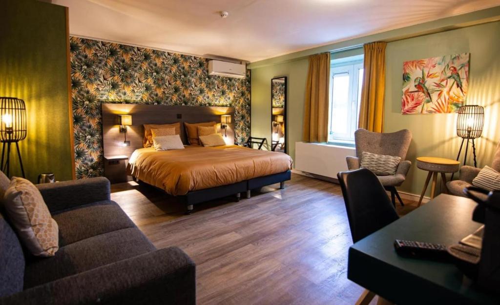 a hotel room with a bed and a couch at Hotel Brasserie de Klok in Zutendaal