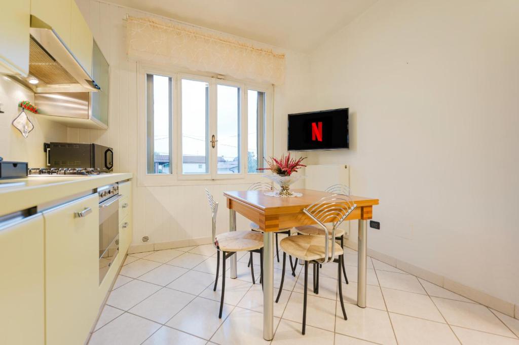 a kitchen with a table and chairs with a clock on the wall at Relax Stay vicino Padova e Brenta in Vigonza