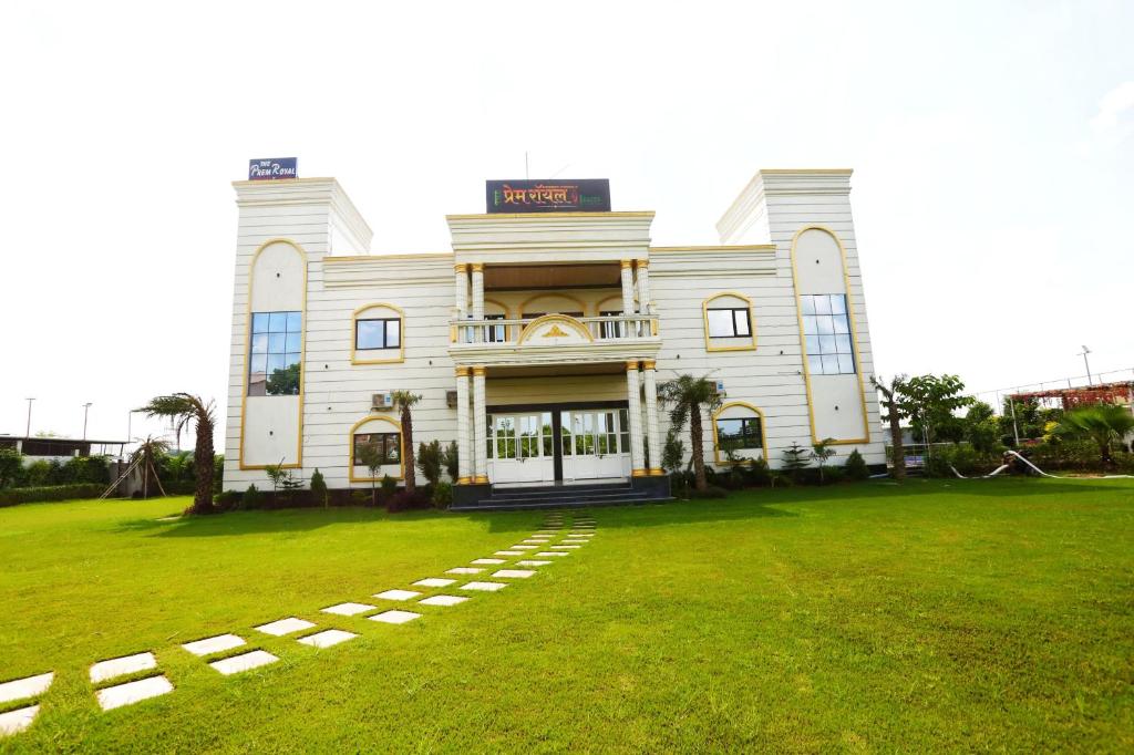 a large white building with a lawn in front of it at The Prem Royal Resort & Hotel in Dāūd Khān