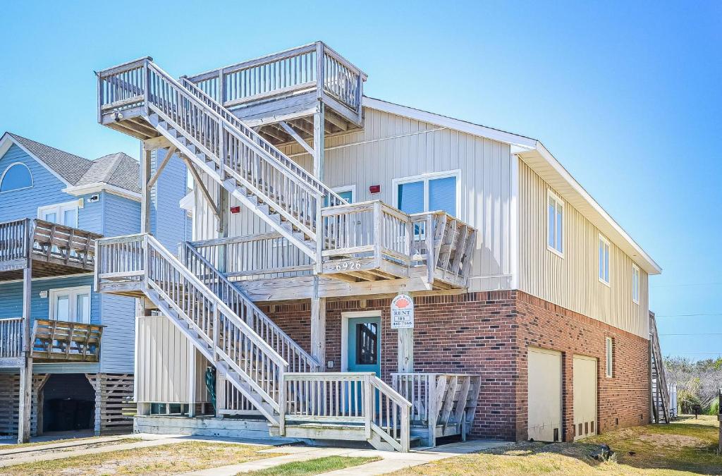 a house with stairs on the side of it at Fun 'N Sun - Nags Head MP 16, 250 Ft to Beach Access, Pool, Pets OK, YR Flex Stays in Nags Head