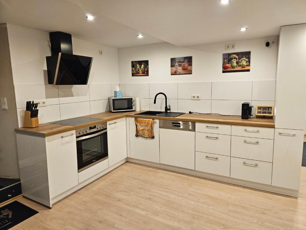 a kitchen with white cabinets and a sink at Ferienwohnung Quierschied in Quierschied