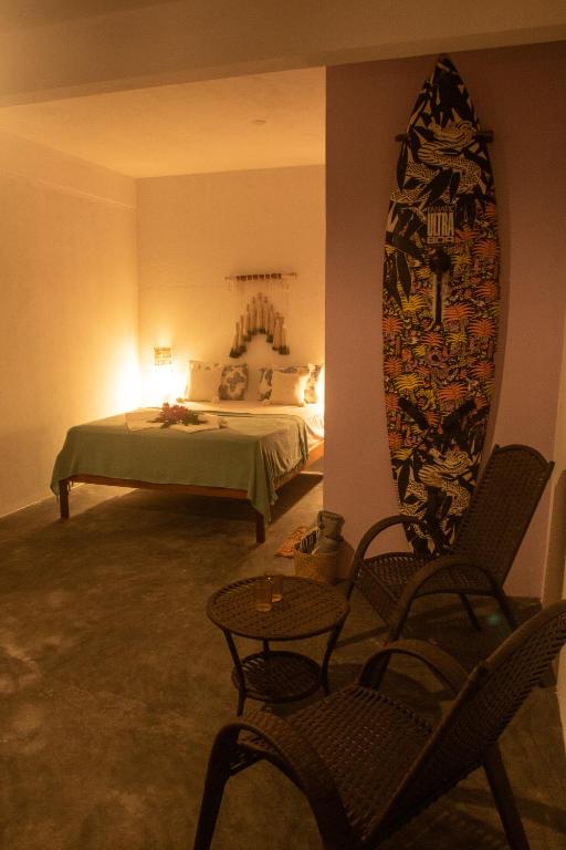 a bedroom with a bed and a table and a mirror at Vila Manguita Suíte Manguita in São Gonçalo do Amarante