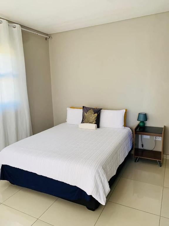 a bedroom with a large white bed in a room at Logo Luxury Guesthouse in Windhoek