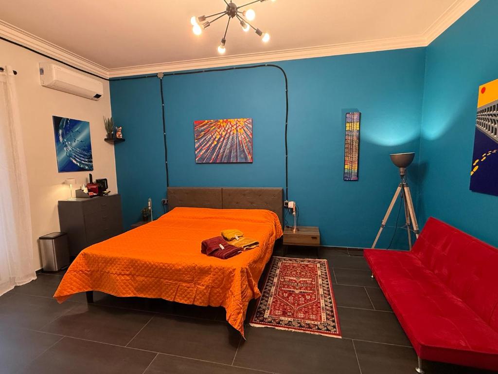 a blue room with a bed and a red couch at Minardi Apartments in Vercelli