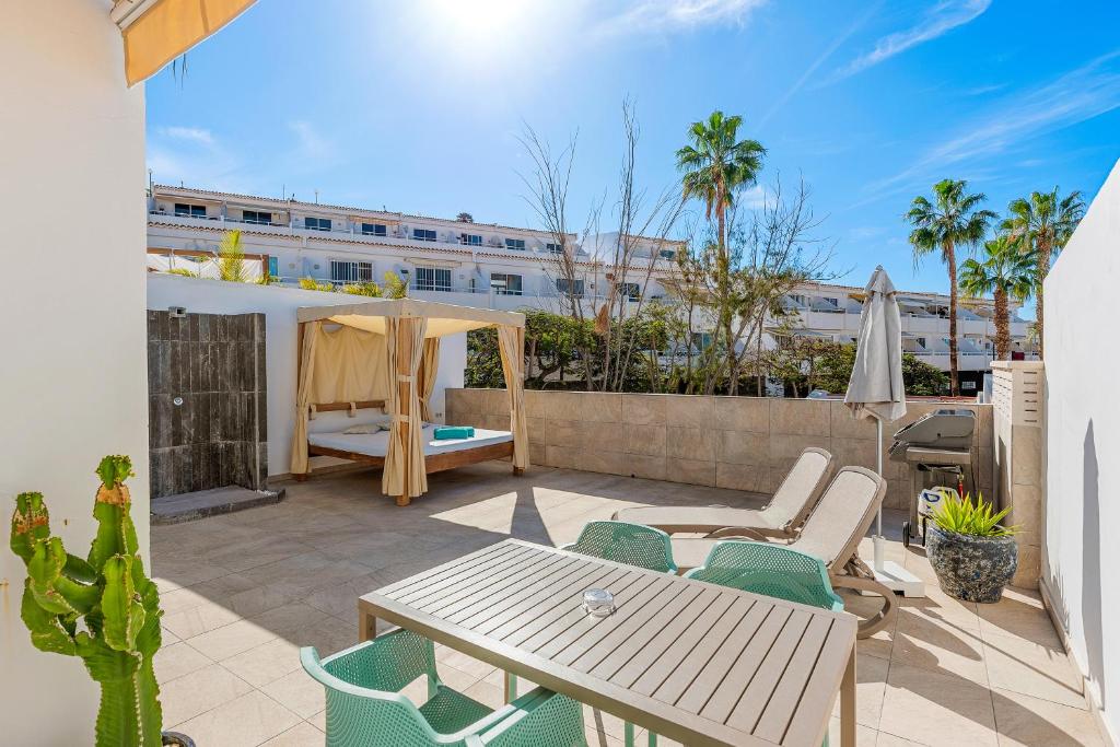 a patio with a table and chairs and a building at Haciendas Village Tenerife in Adeje
