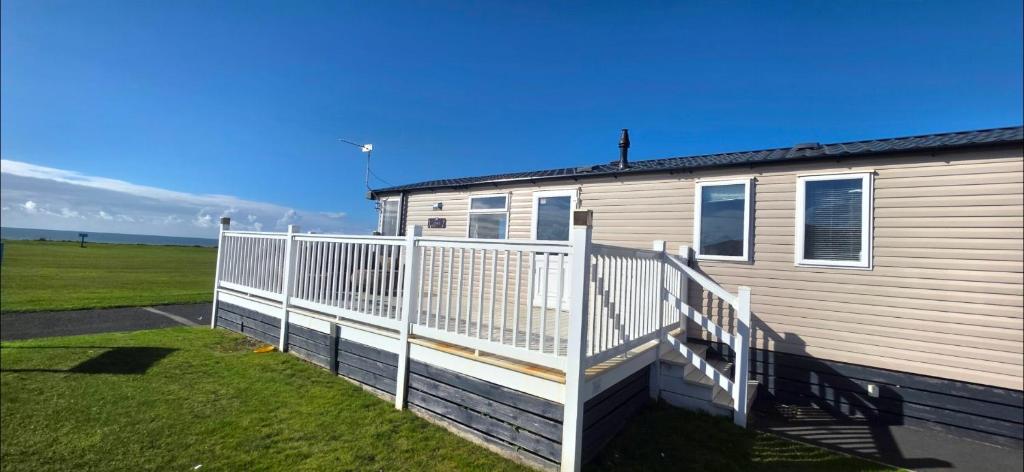 a mobile home with a white railing on a yard at Sea view 1 in Heysham