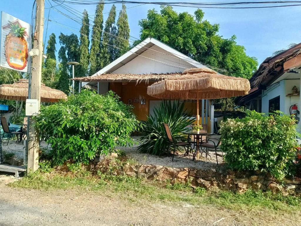 a house with a straw umbrella and a table and chairs at Pineapple Resort Sam roi yot in Sathani Sam Roi Yot