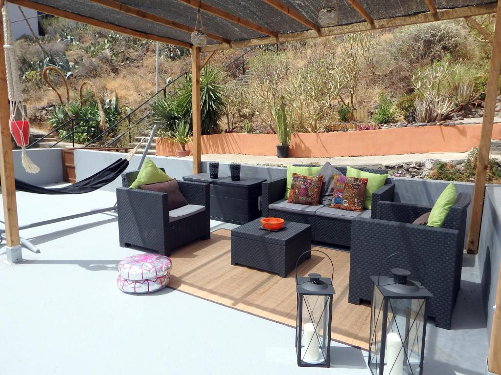 a patio with a couch and chairs and a hammock at La casa de Emma in Los Campitos