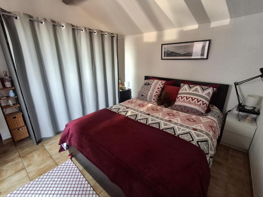 a bedroom with a bed and a window with curtains at Chambre double avec balcon in Sérignan