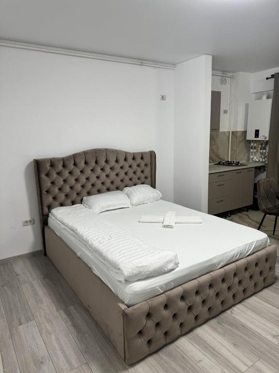 a bedroom with a large bed with a tufted headboard at Pollux Residence Militari Ap 81 in Bucharest