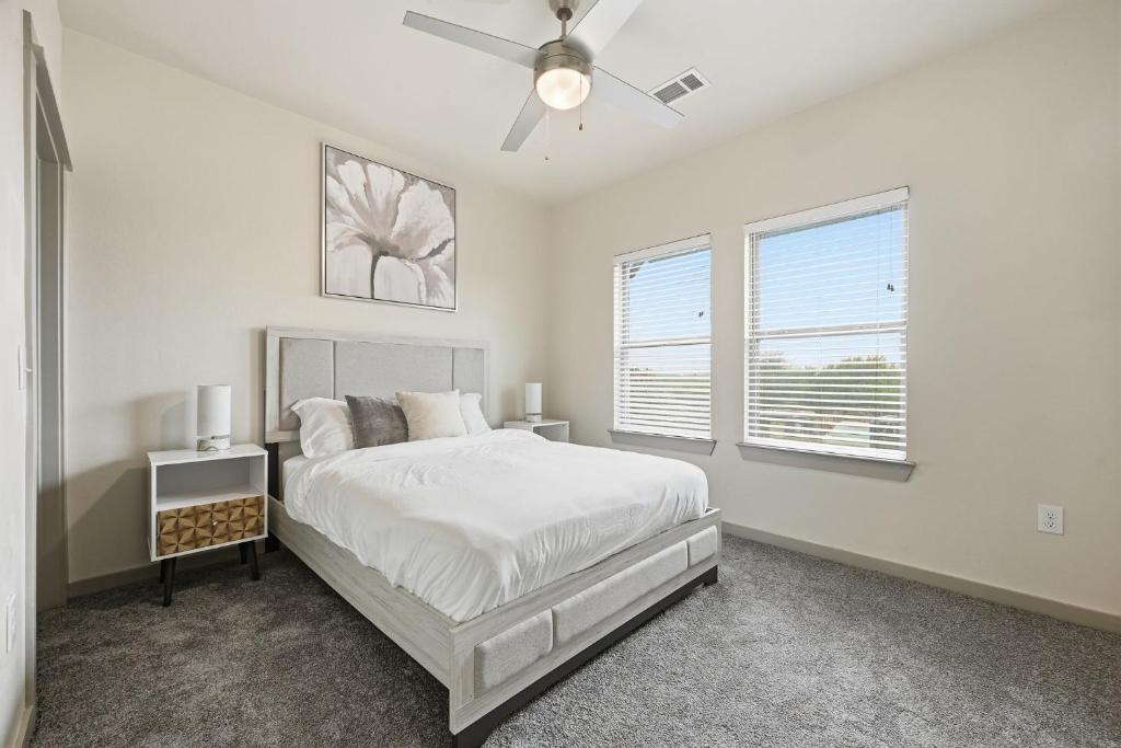 a white bedroom with a bed and a ceiling fan at Chisholm Trace 812 Perfect 2BD 2BA in Cleburne