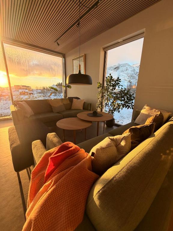 a living room with a couch and a large window at Lofoten Viewpoint 13 in Vestvågøya