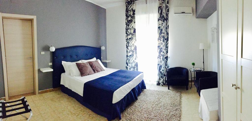 Un dormitorio con una cama azul y una ventana en B&B Civico 46, en Reggio Calabria