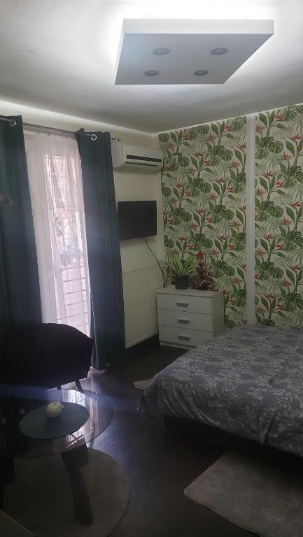 a bedroom with a bed and a chair and a window at Nena Studio in Jagodina