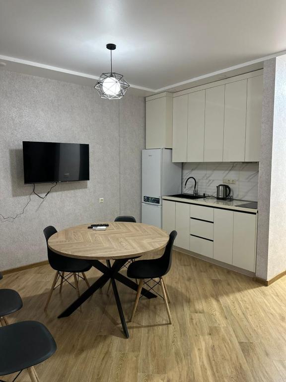 a kitchen with a table and chairs in a room at Ander Tower in Stantsiya Batumi-Passazhirskaya