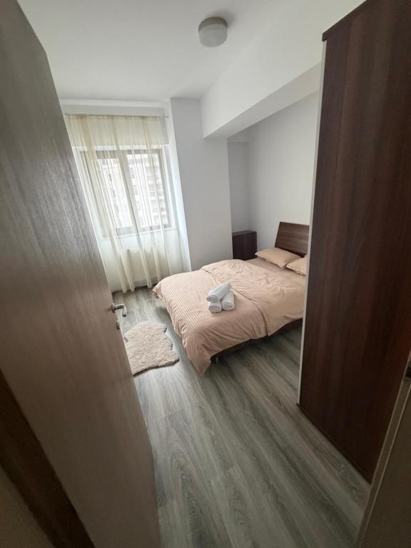 a small bedroom with a bed and a window at Resident aparments two bed with balcony in Bucharest