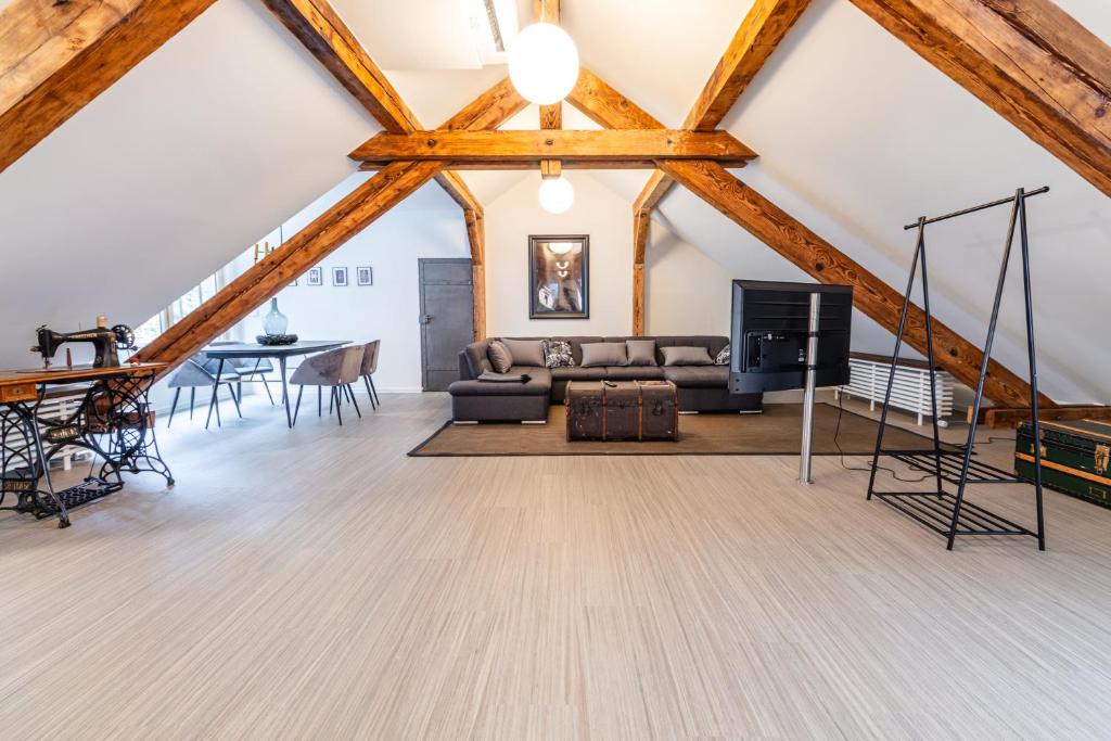 a living room with a couch and a tv at Black Apartment - Large Spacious One Bedroom Penthouse Loft in Baden-Baden