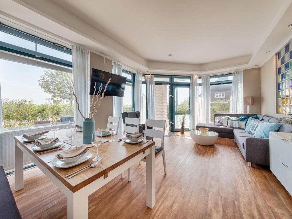 a living room with a table and a couch at Strandburg "Aquamarin" 01 a in Burgtiefe auf Fehmarn 