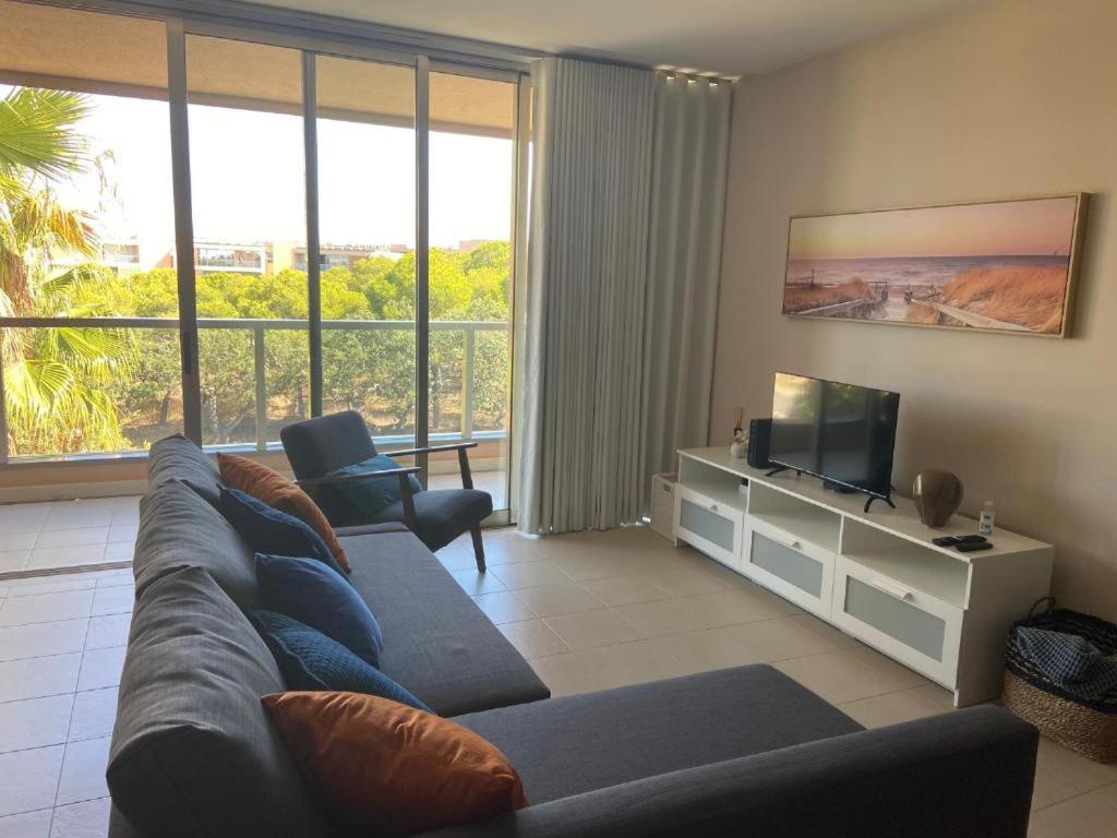 a living room with a blue couch and a television at Salgados Retreat in Bicas