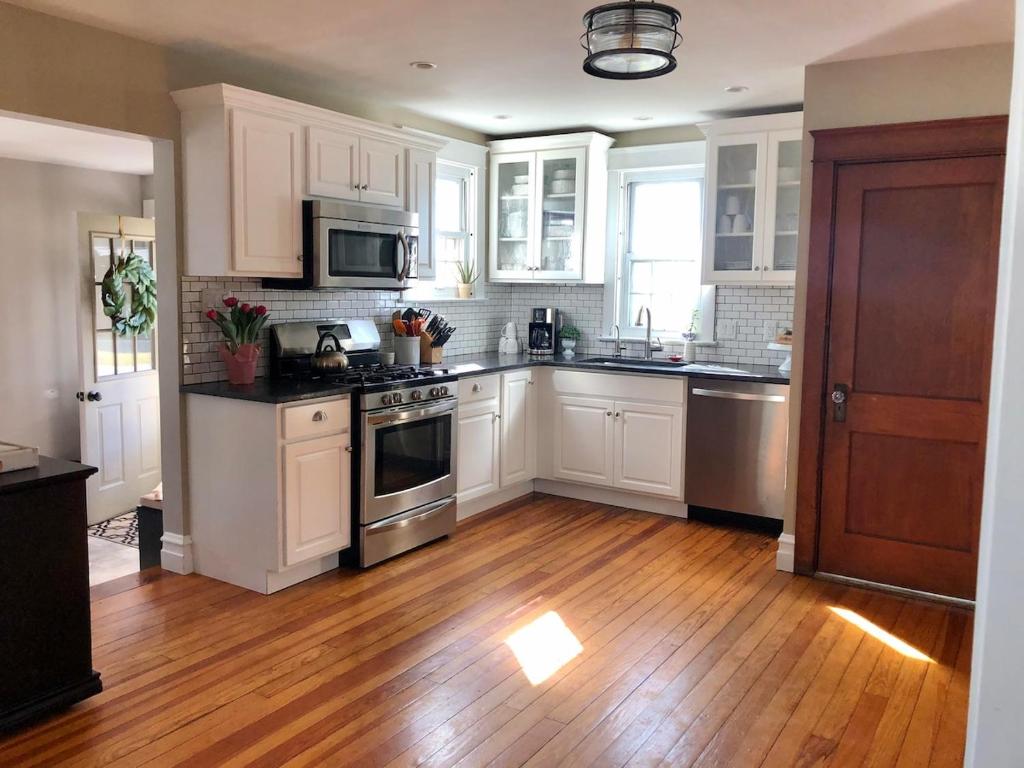 a kitchen with white cabinets and stainless steel appliances at Comfortable Craftsman Getaway in Lancaster