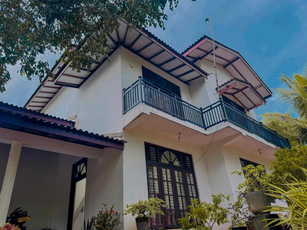 a house with a balcony on top of it at Nathalie Villa in Anuradhapura
