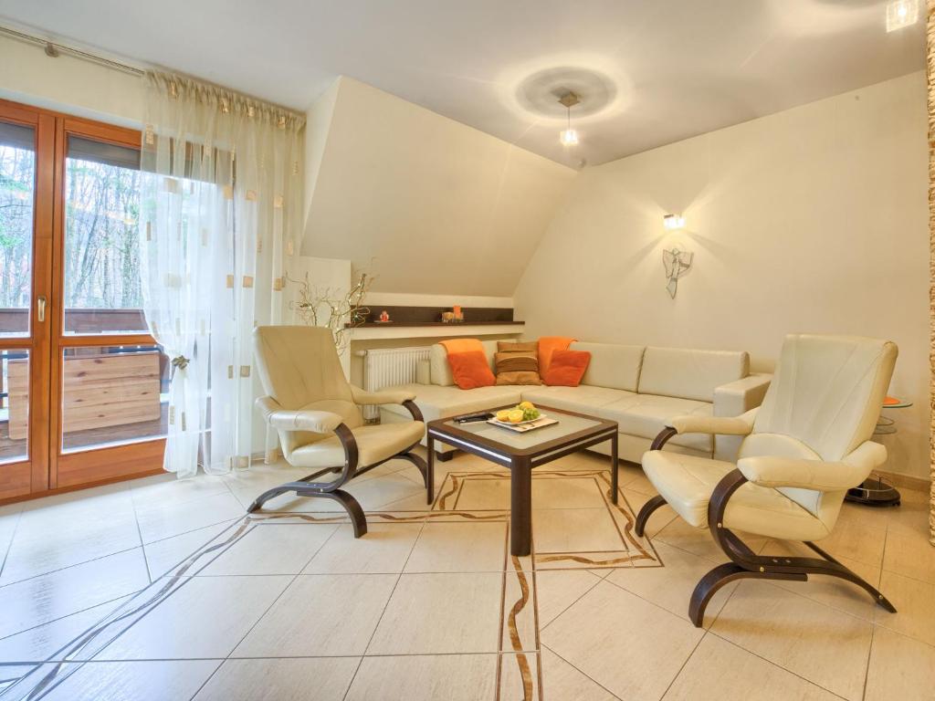 un soggiorno con divano, sedie e tavolo di VisitZakopane - Flower Apartment a Zakopane