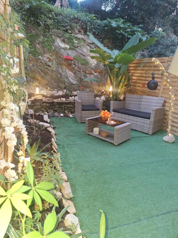 a patio with two couches and a table and a plant at petit cocon in Toulon