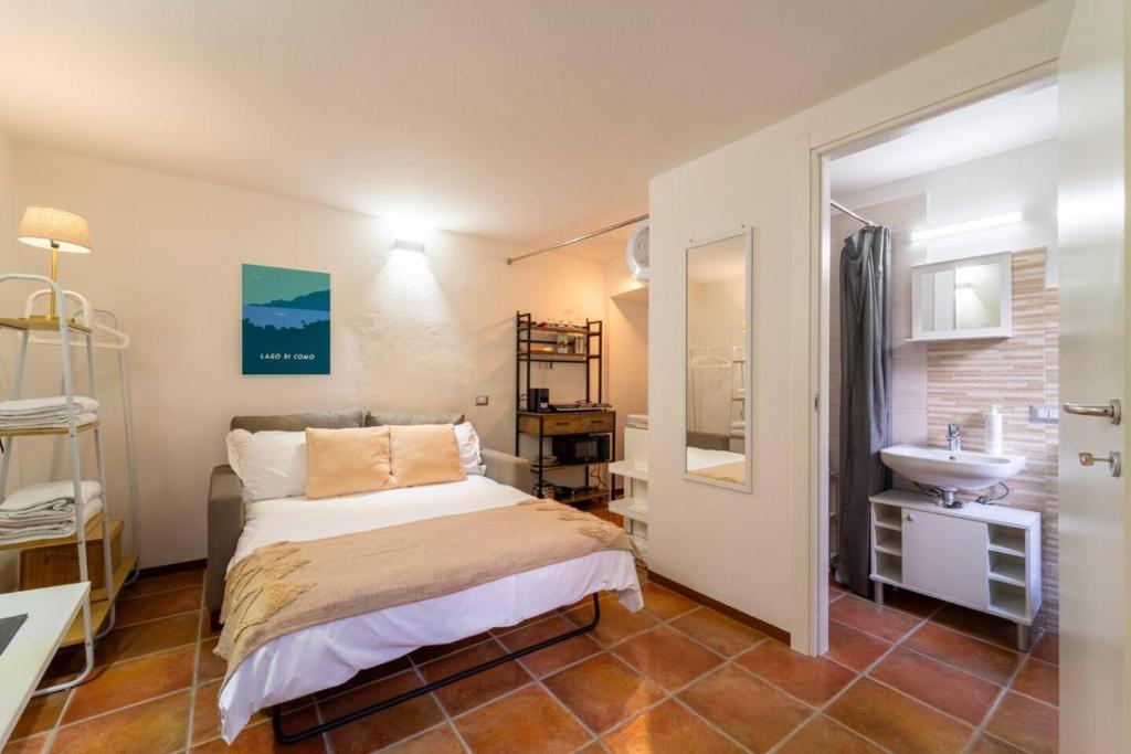 a small bedroom with a bed and a sink at Lilliput Tiny Studio in Bellagio