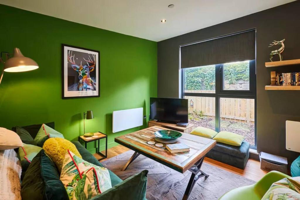 a living room with green walls and a table at 1BR Private Lodge inc Sofa Bed in Alnwick