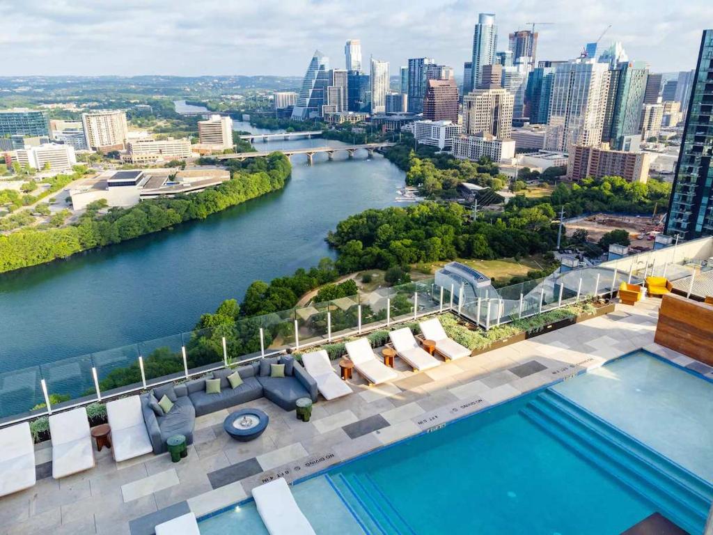 a pool with a view of a river and a city at Luxury 2BR Rooftop Pool Austin by Barclé in Austin