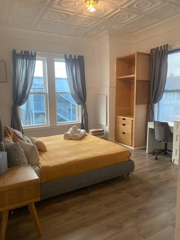 a bedroom with a bed and a desk and windows at No7-Corner Studio in Bridgeport