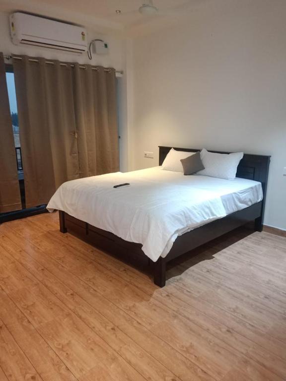 a bedroom with a large bed with white sheets and pillows at Aarna Beach Stay in Vadarevu