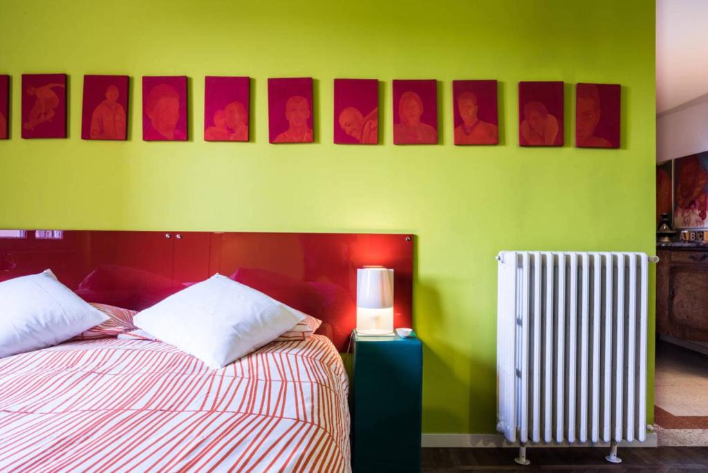 une chambre verte avec deux lits et un radiateur dans l'établissement Abchouse Sant'Agostino, à Milan