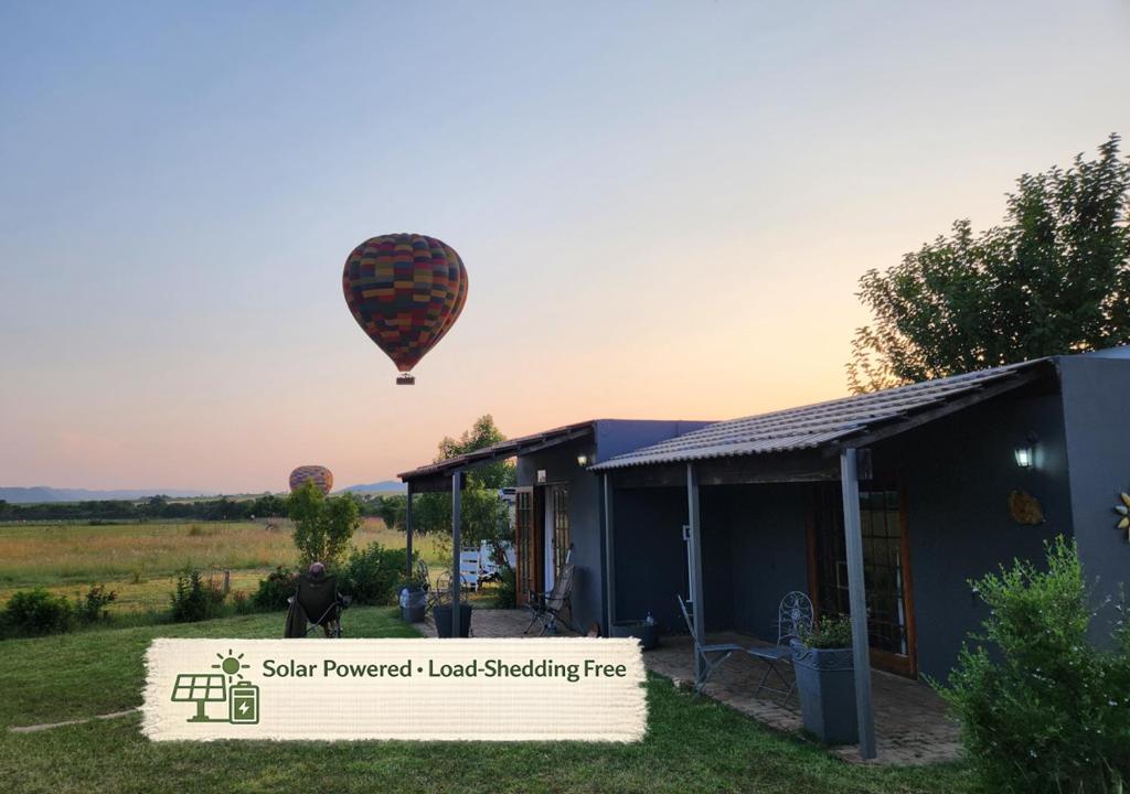 a hot air balloon flying over a house at Blueberry Country Cottage in Brits