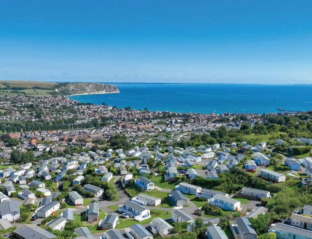 an aerial view of a city with houses and the ocean at Swanage Luxury Caravan - Stunning sea views, Large decking area, Free EE WIFI, Sleeps 6, Pet Friendly on Swanage Bay View Holiday Park in Swanage