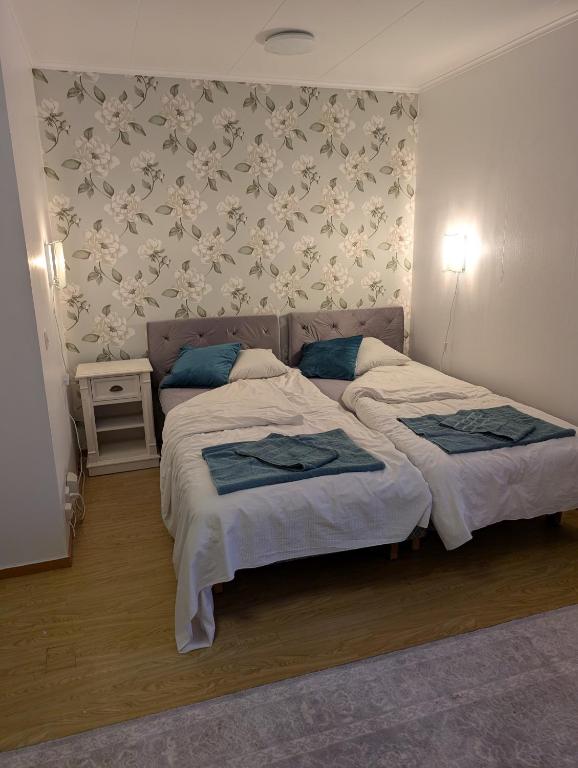 a bedroom with a large bed with blue pillows at Lägenhet nära naturen Pralinette BB in Nykroppa